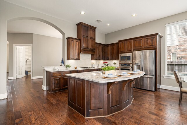 kitchen featuring appliances with stainless steel finishes, baseboards, tasteful backsplash, light stone countertops, and recessed lighting