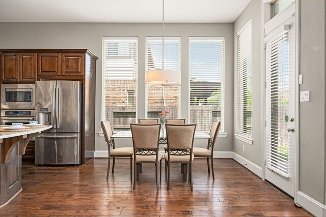 dining area featuring dark wood-type flooring and baseboards
