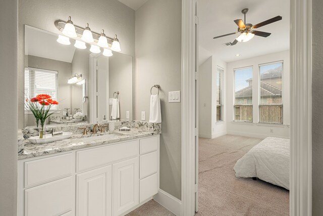 bathroom with ceiling fan, vanity, and baseboards