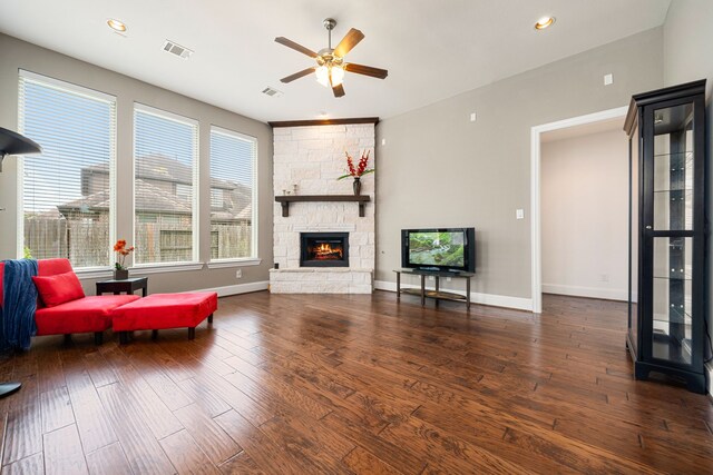 living room with ceiling fan, a stone fireplace, hardwood / wood-style flooring, recessed lighting, and baseboards
