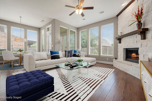 living room featuring wood-type flooring, a fireplace, ceiling fan, and baseboards