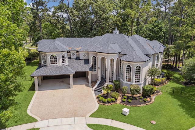11 Twin Greens Ct, Houston, TX 77339 - french country inspired facade with roof with shingles, concrete driveway, stucco siding, and fence