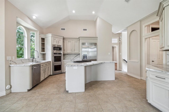 11 Twin Greens Ct, Houston, TX 77339 - kitchen featuring built in appliances, light stone countertops, visible vents, a sink, and a kitchen island