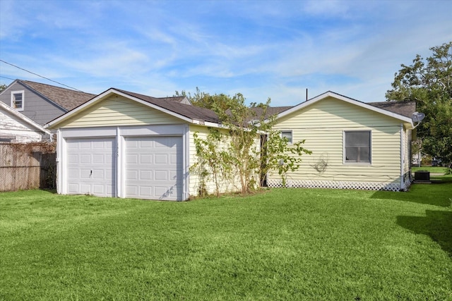 view of front of home featuring a front lawn, central air condition unit, a shingled roof, and an attached garage