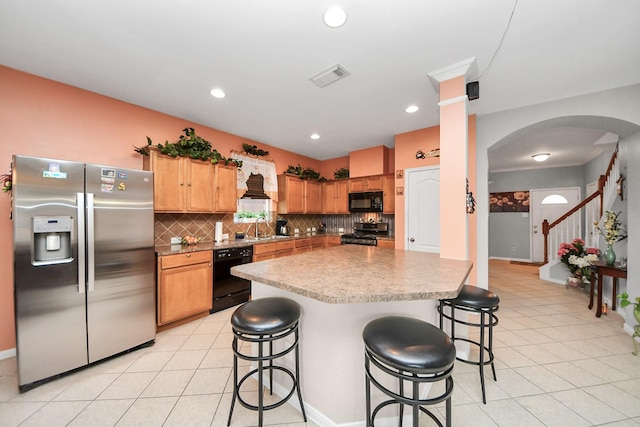 20115 Sunflower Chase Dr, Katy, TX 77449 - kitchen with black appliances, a sink, arched walkways, backsplash, and a kitchen breakfast bar