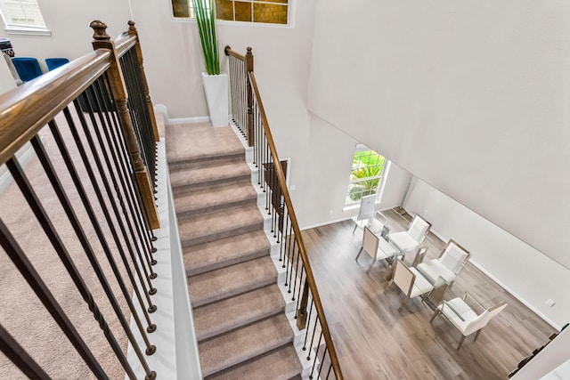 stairway with wood finished floors and baseboards