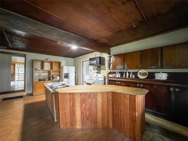 6710 County Road 203, Liverpool, TX 77577 - kitchen featuring open shelves, washing machine and clothes dryer, a kitchen island with sink, white refrigerator with ice dispenser, and black microwave