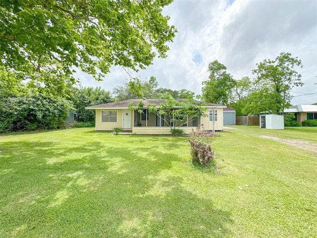 6710 County Road 203, Liverpool, TX 77577 - back of property featuring a yard, an outbuilding, and a sunroom