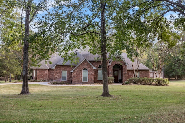 20111 Hilltop Ranch Dr, Montgomery, TX 77316 - view of front facade with roof with shingles, brick siding, and a front yard