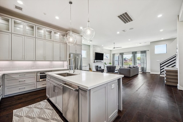 kitchen featuring appliances with stainless steel finishes, visible vents, tasteful backsplash, and a sink