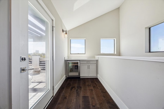 bar with wine cooler, lofted ceiling, a healthy amount of sunlight, and dark wood-style floors