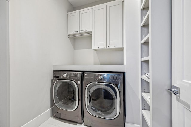 laundry area featuring cabinet space, independent washer and dryer, and baseboards