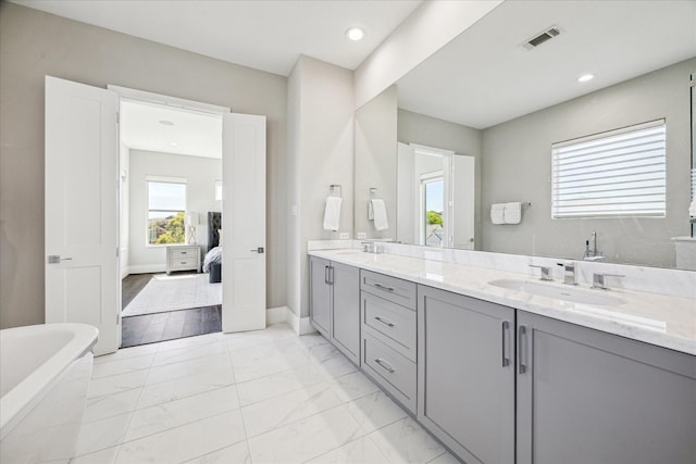 308 Willard, Houston, TX 77006 - ensuite bathroom featuring a freestanding bath, double vanity, marble finish flooring, baseboards, and recessed lighting