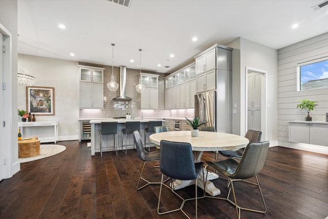 308 Willard, Houston, TX 77006 - dining area with wine cooler, dark wood finished floors, baseboards, recessed lighting, and wooden walls
