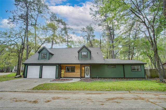 new england style home featuring fence, a front yard, and driveway