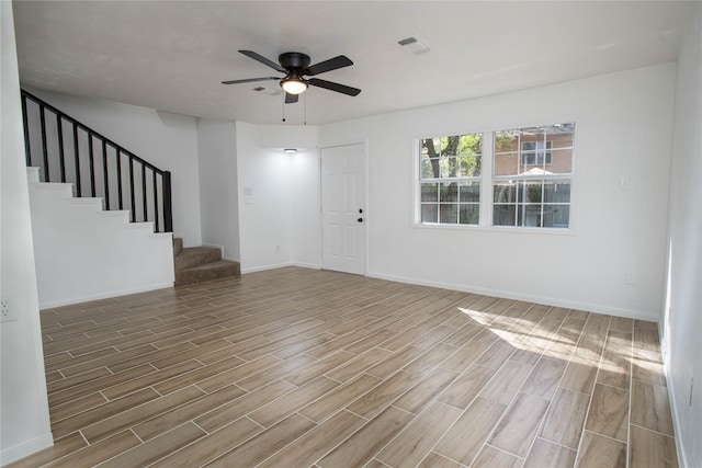 entrance foyer with ceiling fan, stairway, visible vents, and wood finished floors
