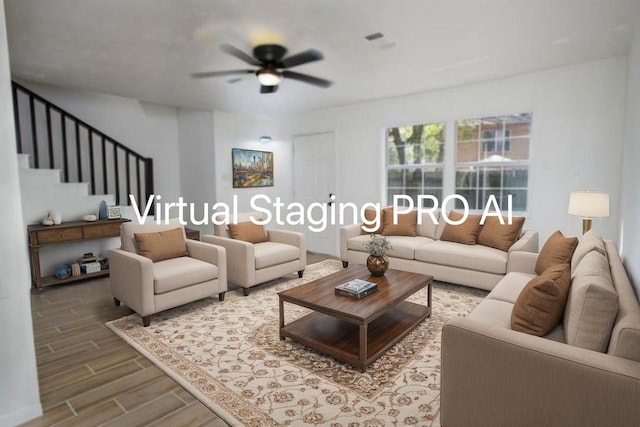 living room featuring stairway, a ceiling fan, visible vents, and wood finished floors