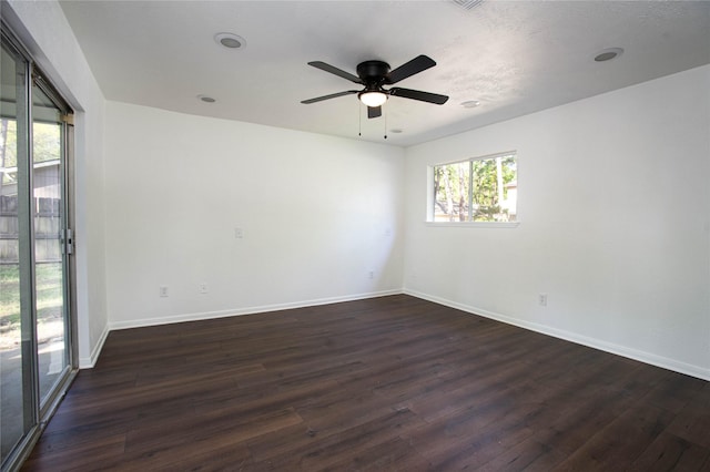 empty room with baseboards, dark wood-style flooring, and ceiling fan