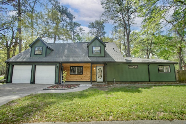 new england style home featuring concrete driveway, fence, an attached garage, and a front lawn