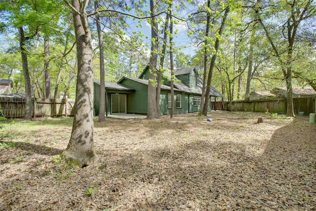 back of property featuring roof with shingles and a fenced backyard