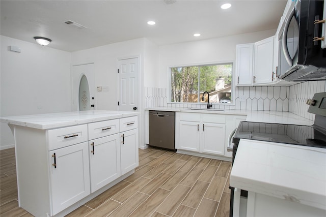 kitchen featuring a sink, stainless steel appliances, light wood-type flooring, visible vents, and light stone countertops