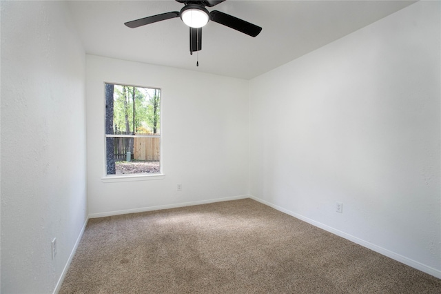 spare room with carpet, baseboards, and ceiling fan