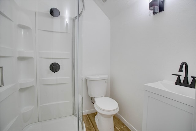 bathroom featuring baseboards, toilet, a shower stall, vanity, and wood finished floors