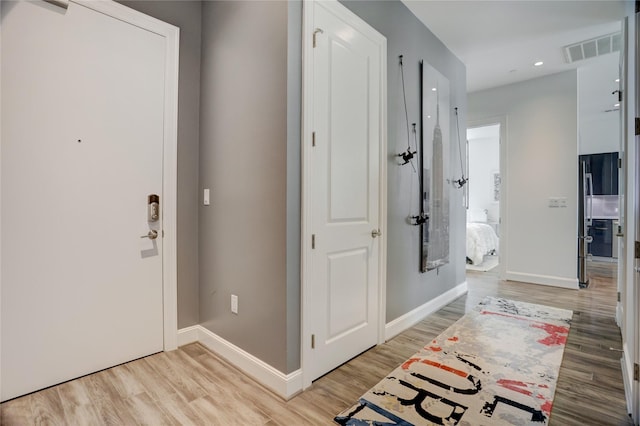 entrance foyer with light wood-type flooring, visible vents, and baseboards