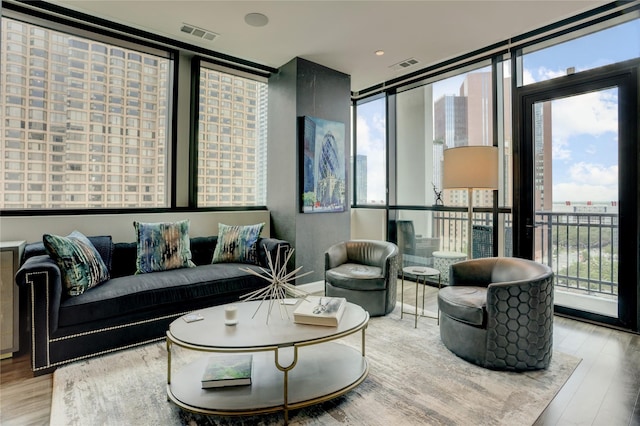 living area with visible vents, wood finished floors, and a healthy amount of sunlight