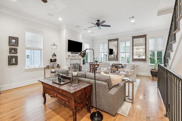 living area with a ceiling fan, baseboards, light wood-style flooring, and visible vents