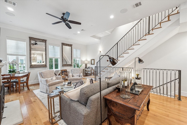 living room featuring visible vents, ceiling fan, and wood finished floors