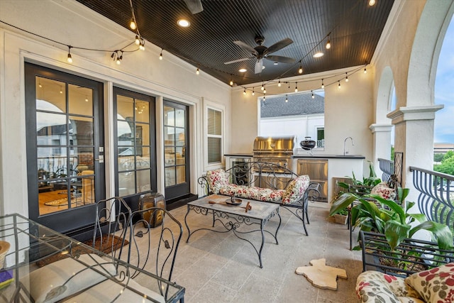 balcony featuring exterior kitchen, a grill, ceiling fan, a sink, and an outdoor hangout area