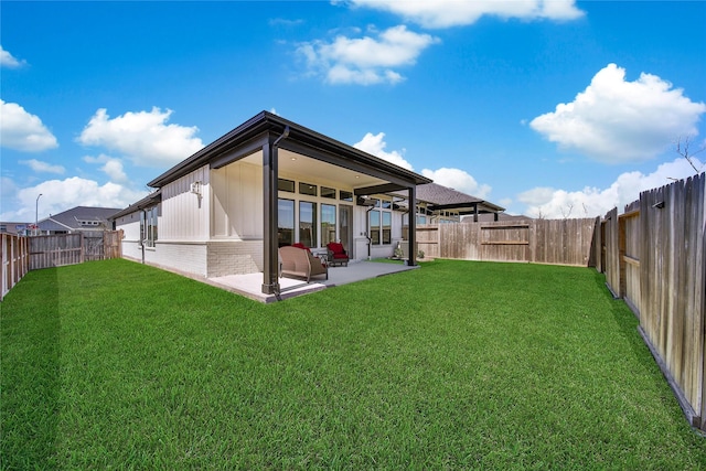 back of property with a lawn, a patio area, brick siding, and a fenced backyard