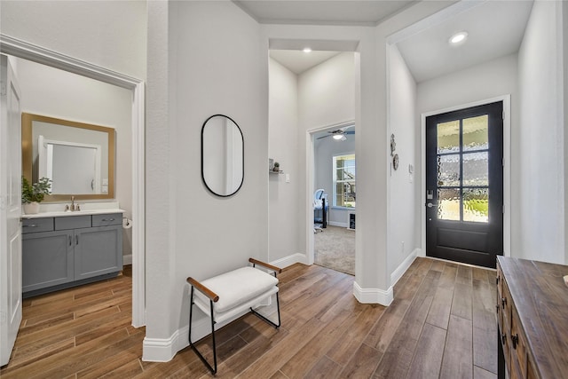 foyer with baseboards, a ceiling fan, and wood finished floors