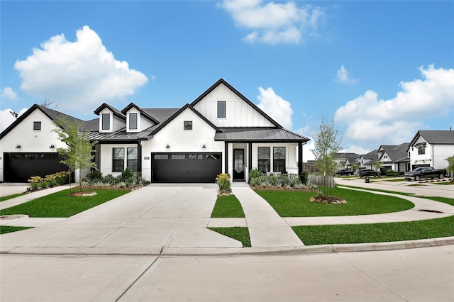 modern inspired farmhouse featuring metal roof, driveway, a standing seam roof, and a front yard
