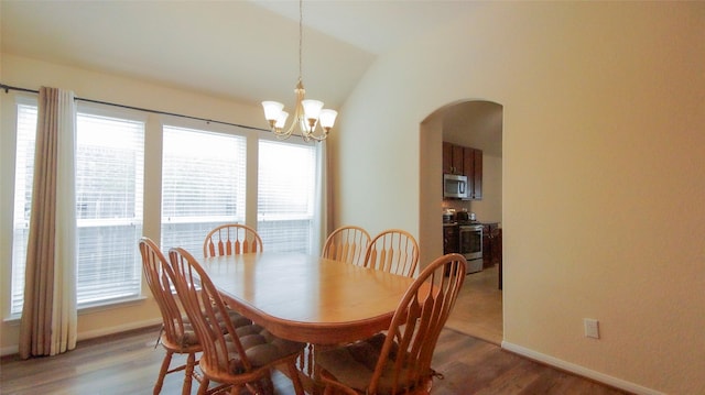 15407 Vincennes Oak St, Cypress, TX 77429 - dining room with lofted ceiling, a notable chandelier, baseboards, arched walkways, and light wood-type flooring