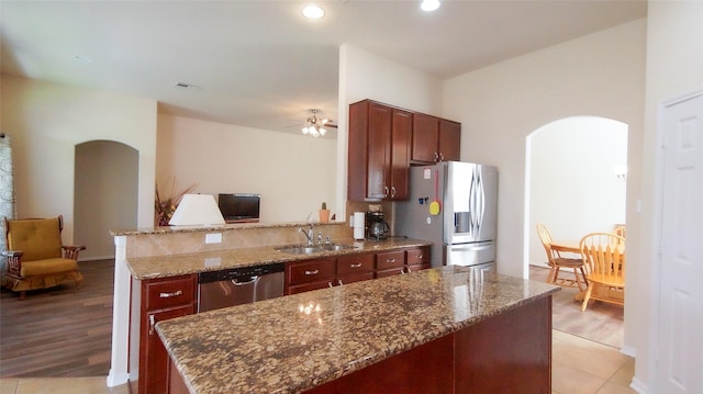 15407 Vincennes Oak St, Cypress, TX 77429 - kitchen with dark stone countertops, stainless steel appliances, arched walkways, and a sink