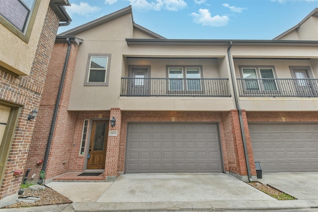 11002 Upland Forest Dr, Houston, TX 77043 - multi unit property featuring a balcony, brick siding, an attached garage, stucco siding, and concrete driveway