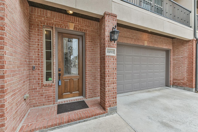 11002 Upland Forest Dr, Houston, TX 77043 - view of exterior entry with concrete driveway, brick siding, and an attached garage