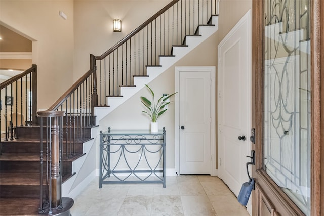 11002 Upland Forest Dr, Houston, TX 77043 - tiled foyer entrance featuring baseboards, stairway, ornamental molding, and a towering ceiling