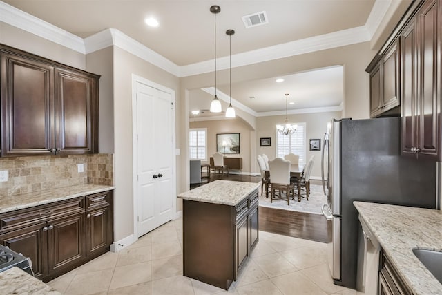 11002 Upland Forest Dr, Houston, TX 77043 - kitchen featuring pendant lighting, dark brown cabinets, light stone counters, visible vents, and decorative backsplash