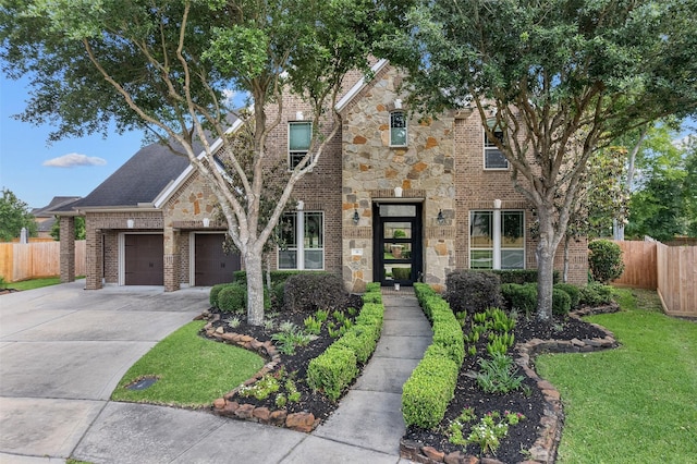 view of front facade featuring concrete driveway, a front yard, brick siding, and fence