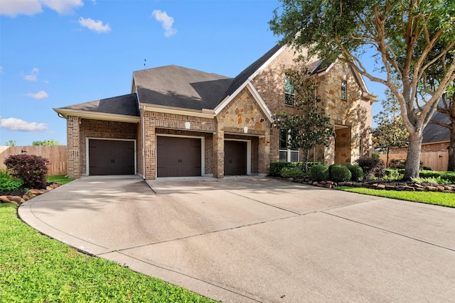 view of front of home with fence, brick siding, concrete driveway, a garage, and a shingled roof