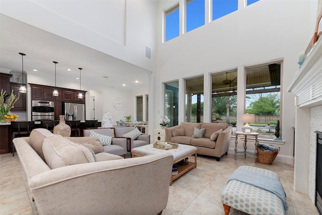 living area with a fireplace, a high ceiling, plenty of natural light, and recessed lighting