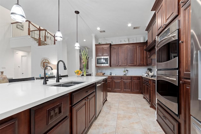 kitchen featuring a sink, visible vents, light countertops, hanging light fixtures, and appliances with stainless steel finishes