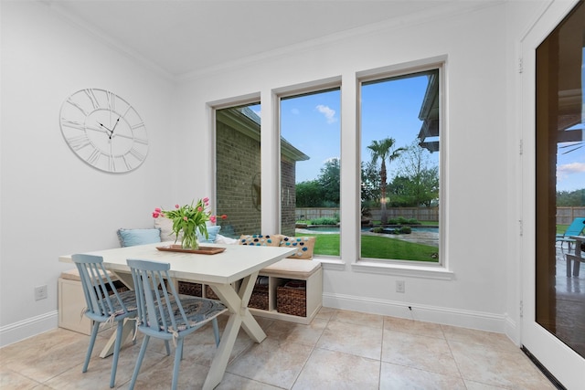 dining area featuring crown molding, a wealth of natural light, baseboards, and light tile patterned floors