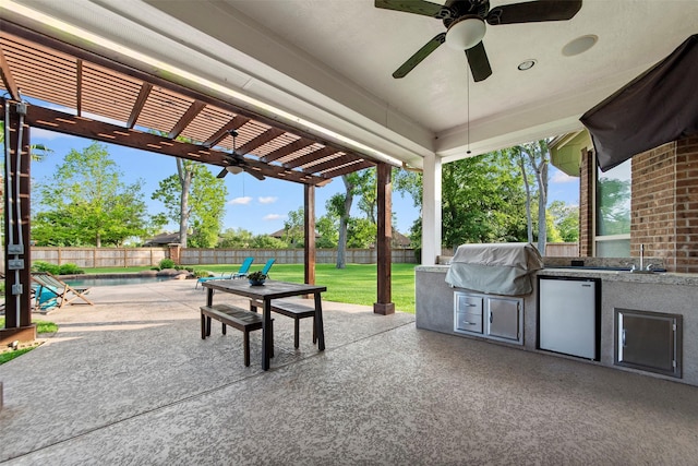 view of patio / terrace with a ceiling fan, exterior kitchen, a grill, a pergola, and a fenced backyard