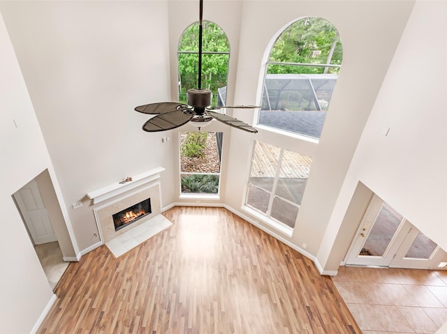 unfurnished living room with baseboards and a towering ceiling