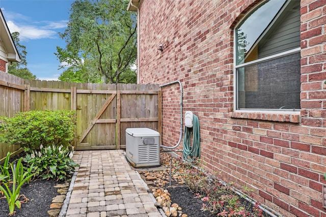 details with brick siding, fence, and a power unit