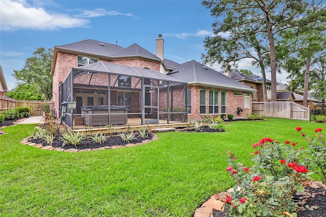 back of house with a yard, a chimney, a fenced backyard, and glass enclosure